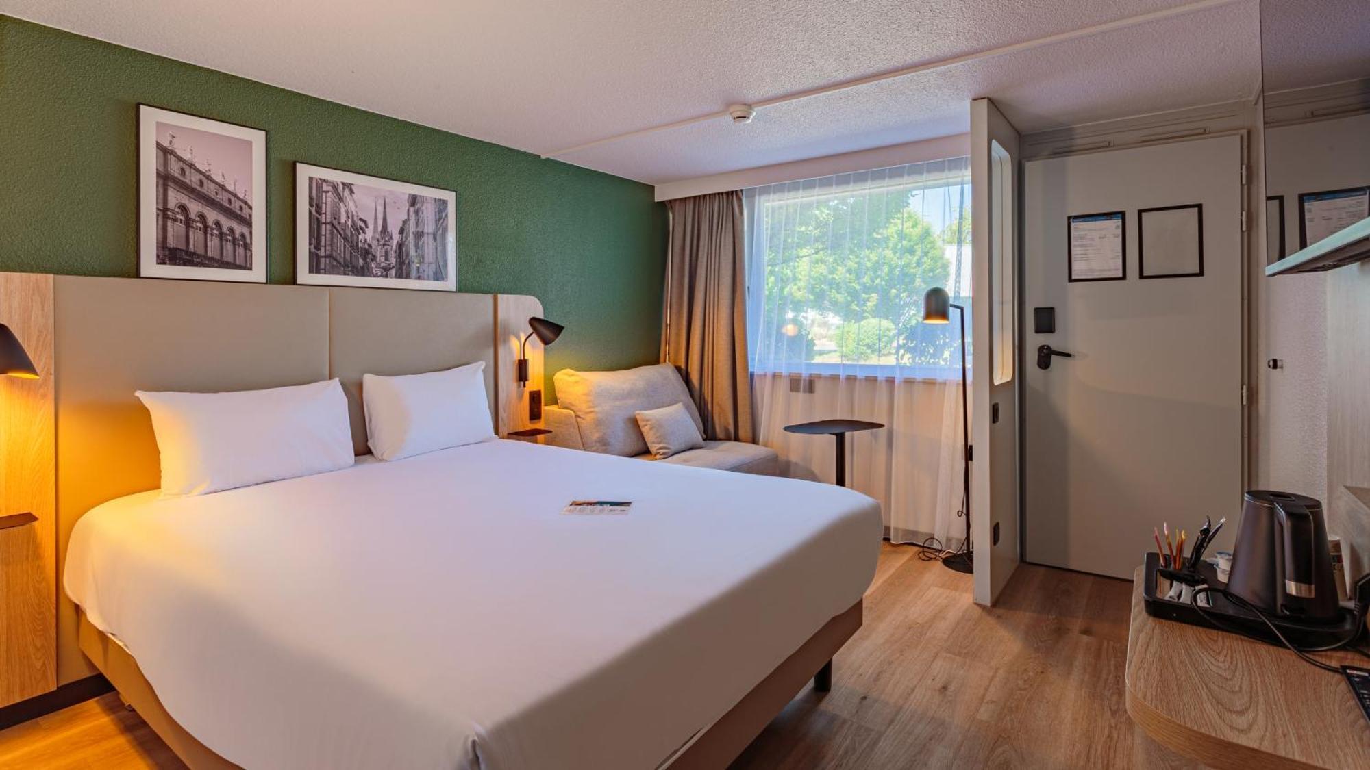 Habitación Doble Estándar con cama doble grande y sofá cama.